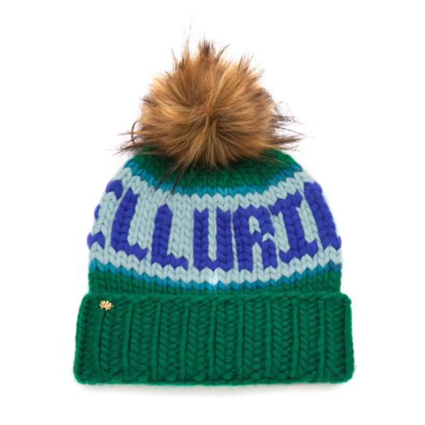 The Faire Knit Ski Hat is a luxury green beanie with blue and light blue patterns, a large brown faux fur pom pom, and a gold flower pin on the cuff.