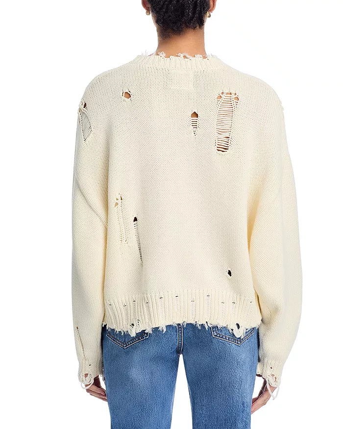A person is shown from the back against a plain white background, wearing Denimist's OVERSIZED CROPPED AMERICAN FLAG SWEATER with an oversized fit and distressed details, paired with blue jeans.