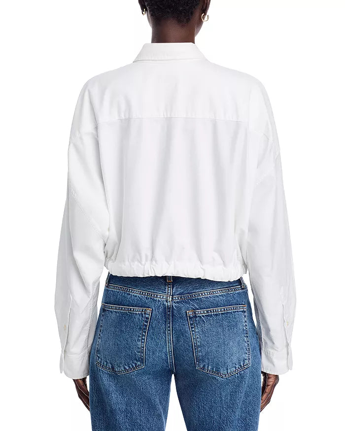 A person is seen from the back wearing the Denimist L/S FRONT TIE SHIRT WHITE S26, a crisp 100% cotton long-sleeve shirt with a point collar, tucked into blue high-waisted jeans against a plain white background.