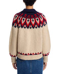 A person seen from the back wears The Great Inc.’s “The Nordic Sweater” in beige, featuring a collared neck and red, navy, and cream Fair Isle pattern on the yoke and cuffs, paired with blue jeans.