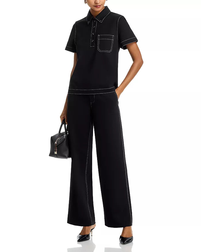 A person is wearing Rag & Bone Irina Pont Contrast Stitch Pants, a black short-sleeve collared shirt with white stitching, black pointed-toe heels, and holding a small black handbag; only part of the face is visible.