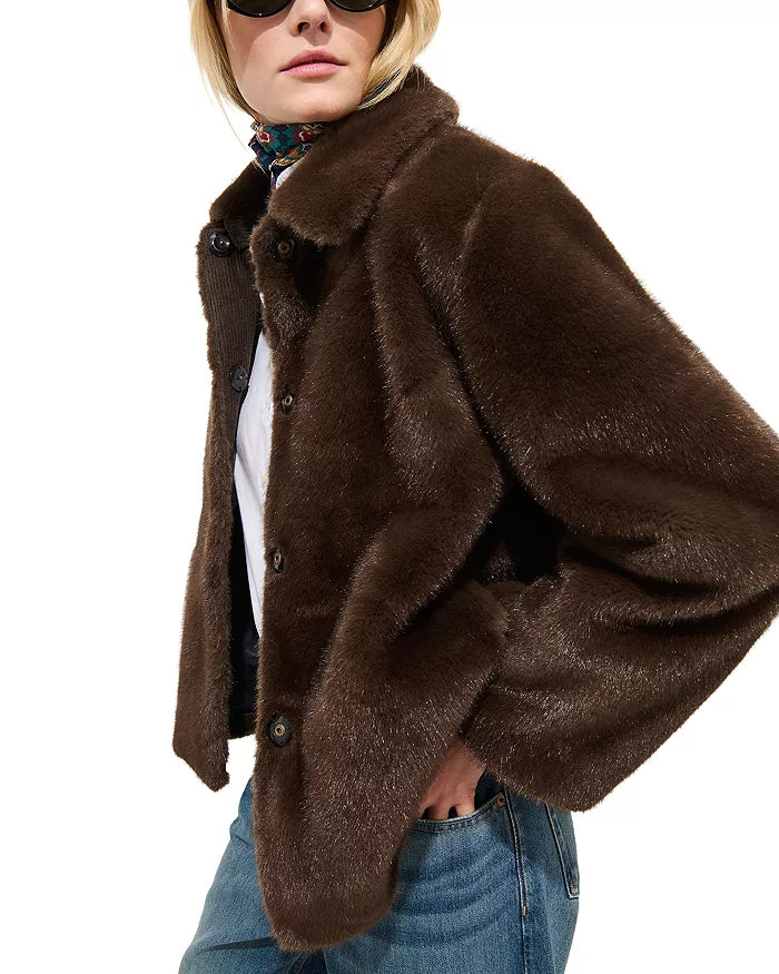 A person wearing the Alex Mill Duane St Jacket in dark brown faux fur, styled with blue jeans, a colorful scarf, and sunglasses, poses with one hand in their pocket against a plain white background.