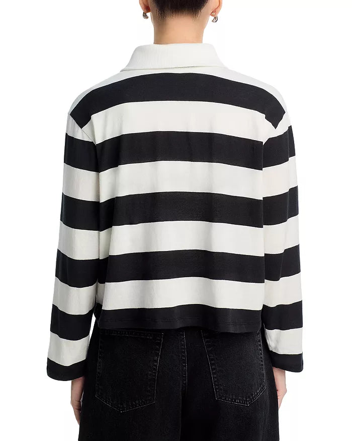 A person is shown from the back wearing the ASKK Long Sleeve Polo, featuring black and white horizontal stripes, a spread collar, and a relaxed fit, paired with black pants.