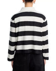 A person is shown from the back wearing the ASKK Long Sleeve Polo, featuring black and white horizontal stripes, a spread collar, and a relaxed fit, paired with black pants.