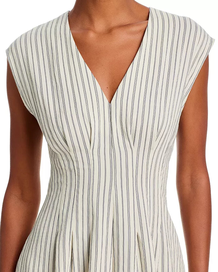 A person wears the Rag & Bone ines stripe satin dress, a cream V-neck sleeveless style with thin vertical black stripes, a fitted bodice, subtle pleating below the waist, and an elegant flowing silhouette.