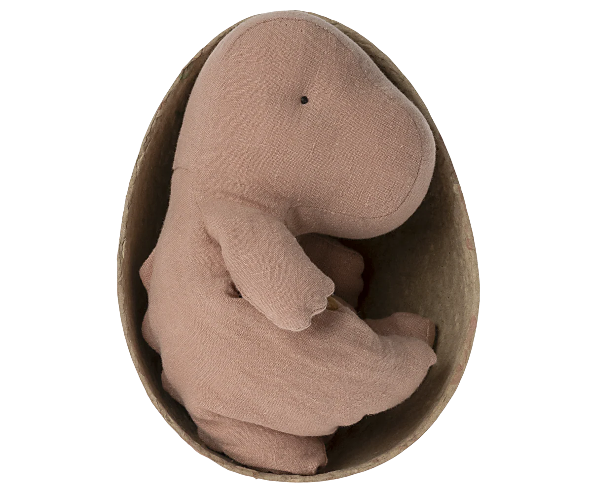 The Maileg Gantosaurus in Egg is a soft, brown dinosaur cuddly toy nestled inside a brown egg-shaped container, shown from above on a plain white background.