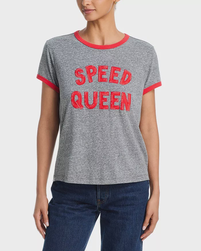A person wearing Mother’s The Boxy Goodie Goodie Ringer—a grey crewneck T-shirt with bold red letters and ringer trim—paired with blue jeans.