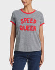 A person wearing Mother’s The Boxy Goodie Goodie Ringer—a grey crewneck T-shirt with bold red letters and ringer trim—paired with blue jeans.