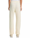 A person is shown from the back wearing The Dance Pant by The Great Inc. in a cream-colored fleece. Made from 100% cotton, these sweatpants feature a relaxed fit, elasticized waistband, and a straight-leg silhouette. Only the lower back and legs of the person are visible.