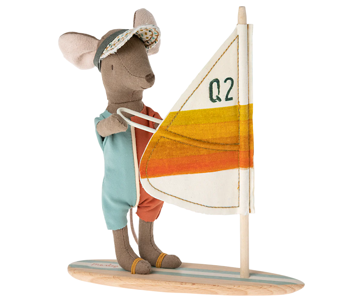 The Maileg Mouse by Maileg wears a visor and aqua-orange outfit, stands on a wooden surfboard, and holds a "Q2"-marked sail with white, yellow, and orange stripes—perfect for fun adventures with your mice family.