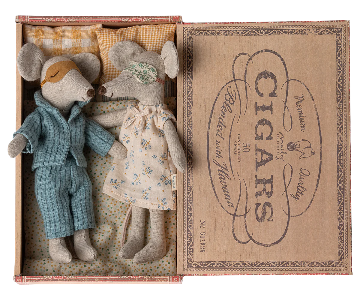 Two Maileg Mice by Maileg, dressed in pajamas and sleep masks, lie side by side in a cozy bed inside a vintage cigar box, tucked in with tiny pillows and blankets for a sweet, peaceful scene.