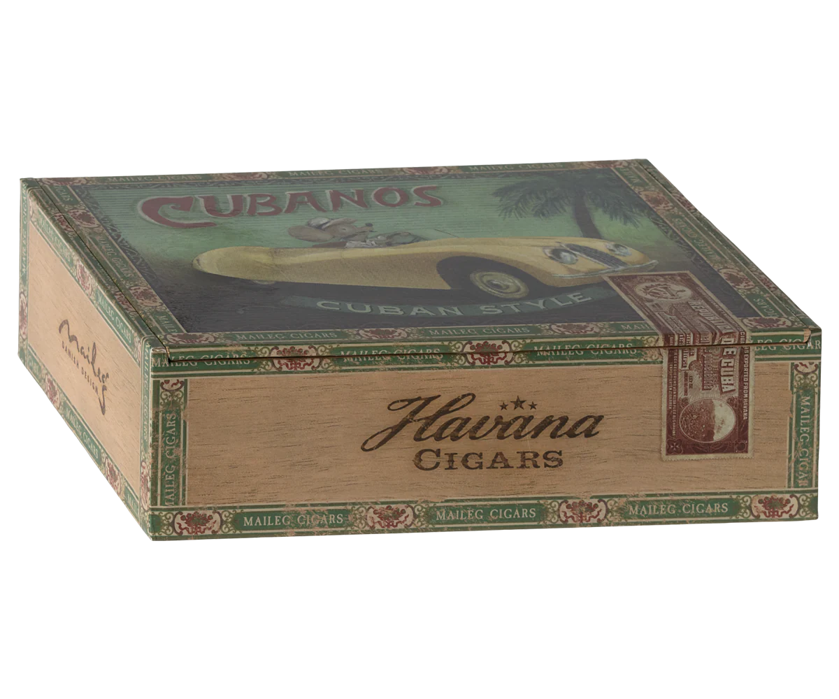 The Maileg Grandma & Grandpa Mice come in a decorative "Haviva Cigars" box with vintage-style artwork, including a yellow car and "CUBANOS CUBAN STYLE," plus ornate green and brown borders—a cozy matchbox bed for these charming Maileg mice.