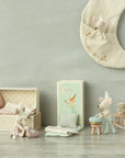 A charming scene features Maileg Tooth Fairy Mice by Maileg in a pastel room: one on a polka-dot bed, another with a mug on a stool, and two atop crescent moon decor. Delicate bedding, boxes, and a tiny tooth box complete the cozy setup.