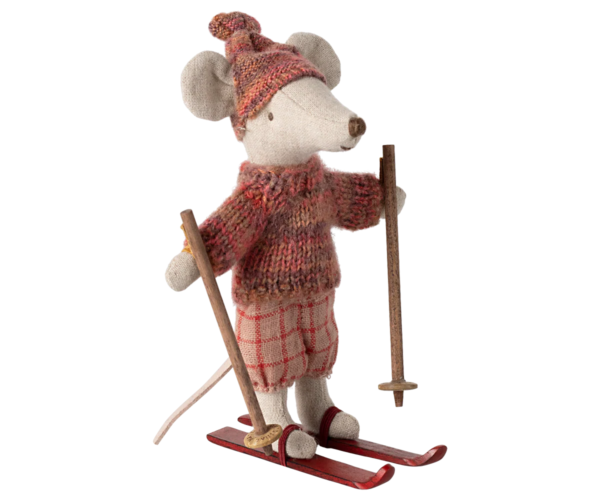 The Maileg Mouse by Maileg is a stuffed toy dressed in a red knit hat and sweater with plaid pants, standing on red skis and holding ski poles.