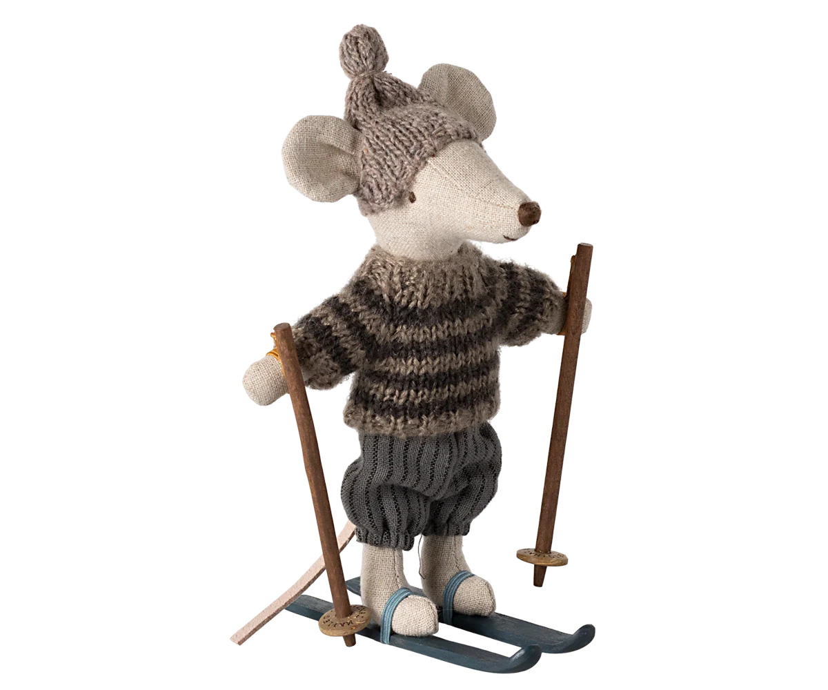 The Maileg Winter Mouse by Maileg is a plush Christmas mouse dressed in a knitted hat, striped sweater, and pants, standing on blue skis and holding wooden ski poles.