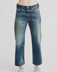 Model wears Denimist LUCY BF JEAN ESHER BLUE, a relaxed fit, high-waisted boyfriend jean with faded thigh details, paired with white sneakers against a plain white background.