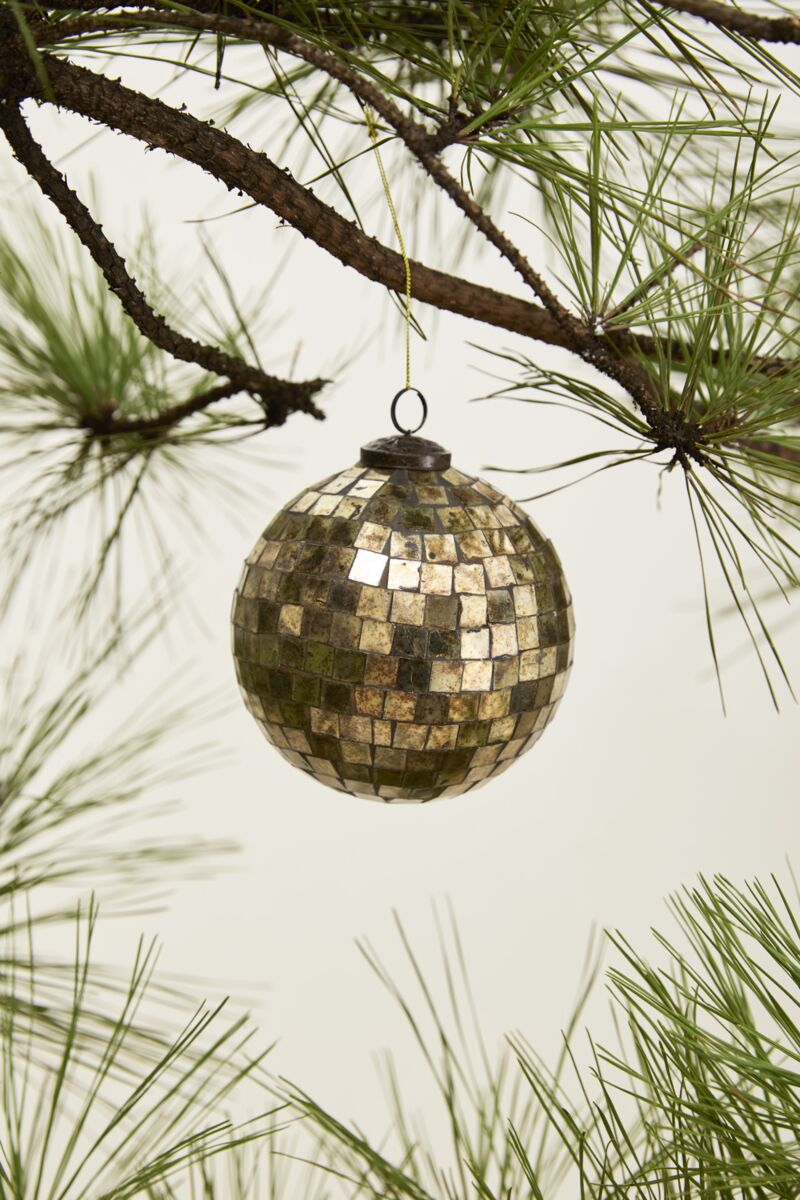 The Accent Decor Antiqued Disco Bal Orn 5" is a vintage-style ornament with a mosaic gold look, hanging from a pine tree branch with green needles against a neutral background.