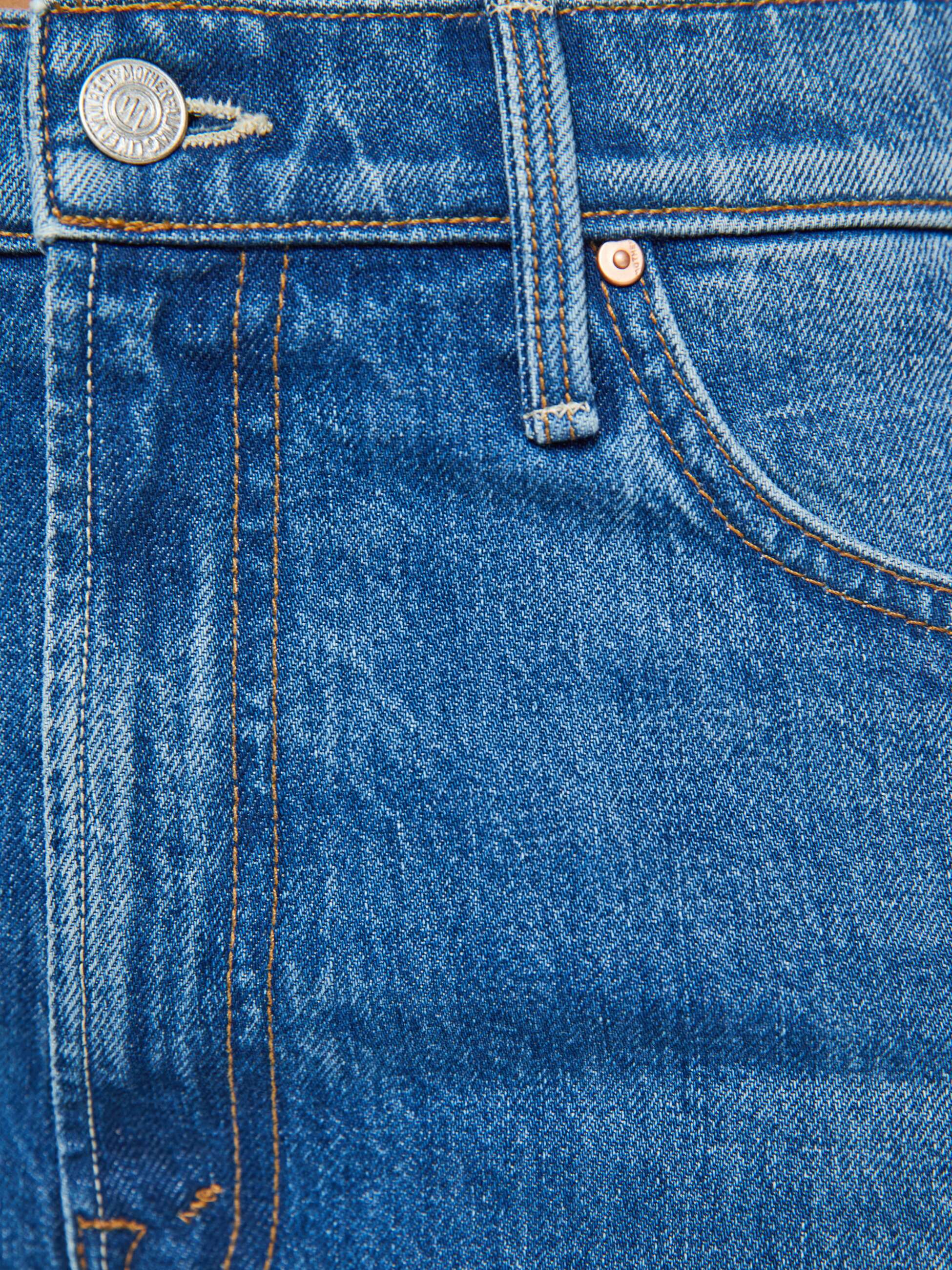 Close-up of The Dodger Ankle jeans by Mother, featuring a cotton blend in blue denim with visible orange stitching on the waistband, button, belt loop, and front pocket.