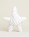 The Faire Starfish Warmies is a white, ribbed microwavable plush pillow with a light pink border, shaped like a starfish and shown upright against a light background, providing soothing warmth for relaxation.