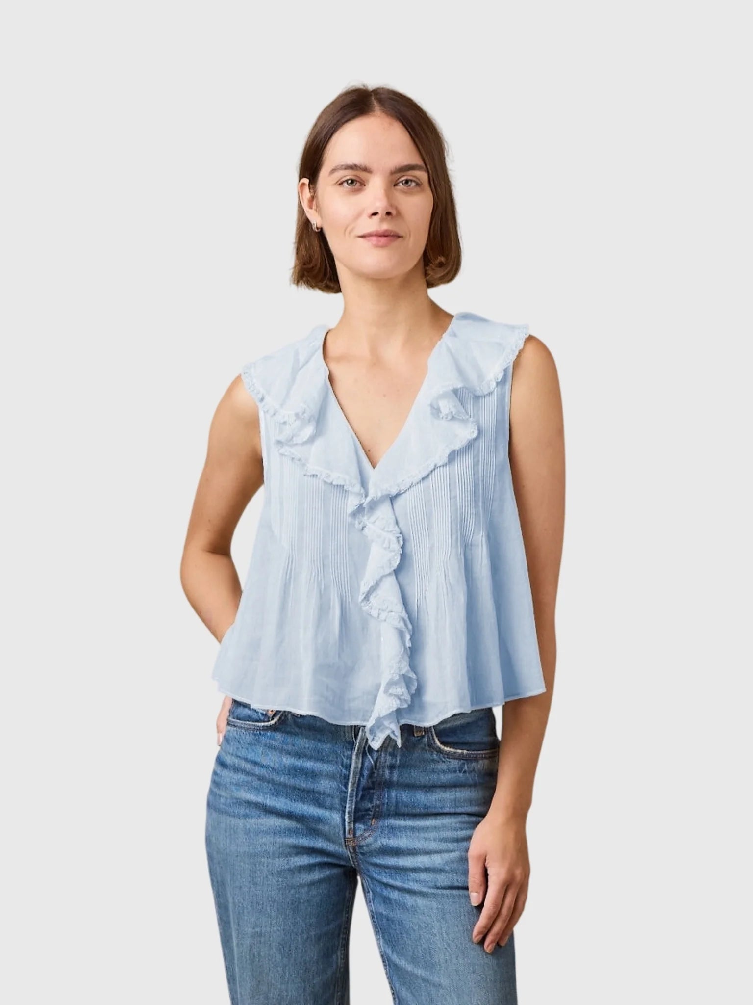 DOEN Hilda Top in organic cotton with lace ruffles, styled with blue jeans against a neutral background.