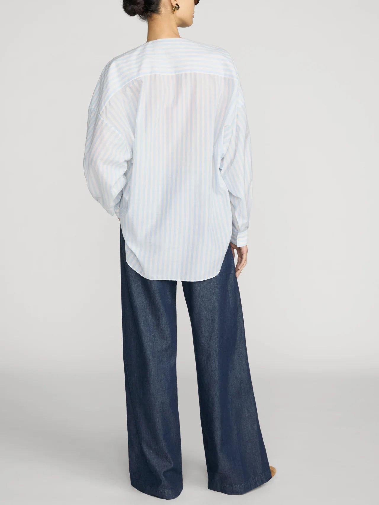 FRAME Offshore Pant in relaxed wide-leg fit, shown from the back with a loose blue striped shirt.