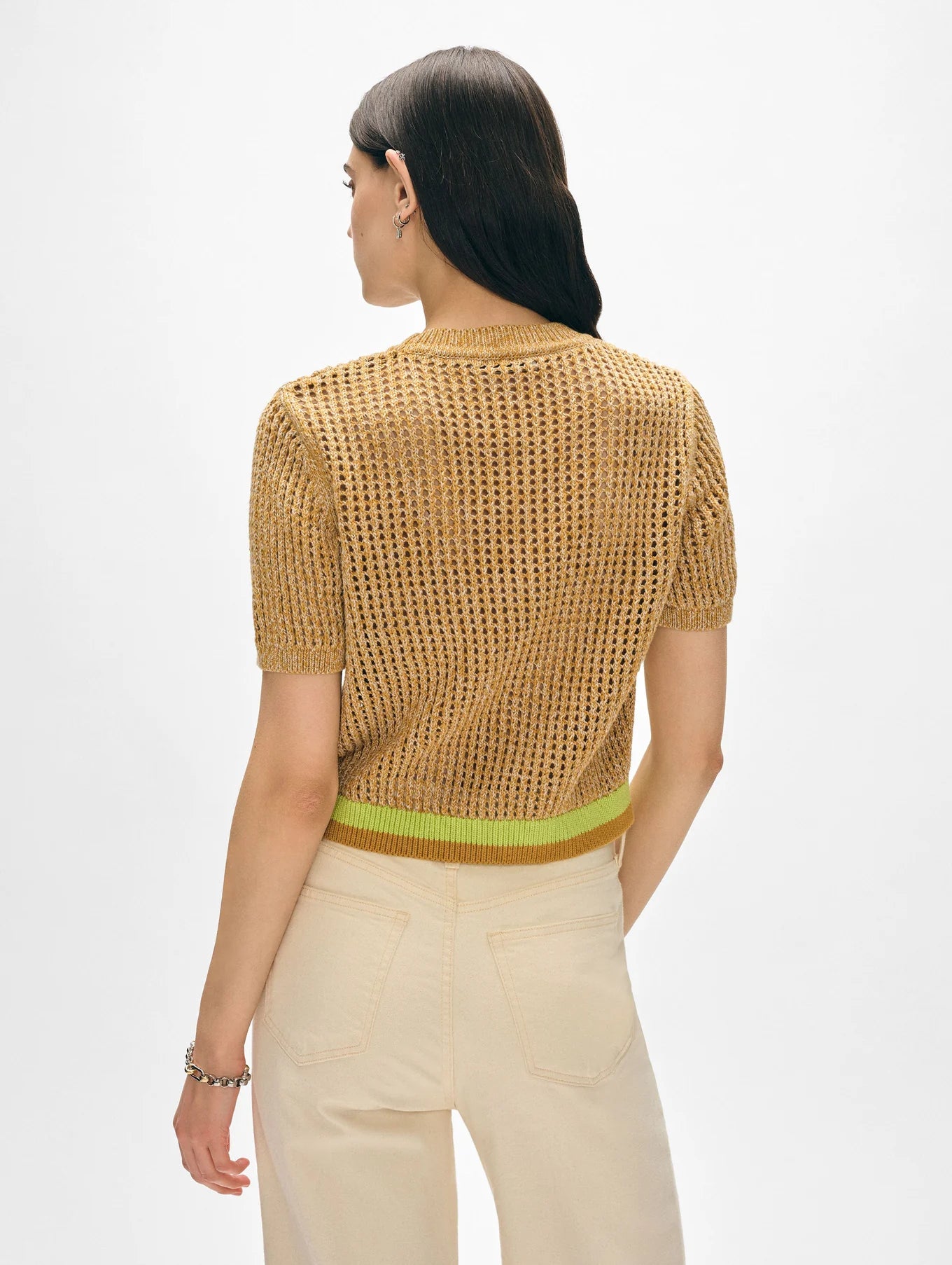 Woman with long dark hair wearing the White + Warren Organic Cotton Mesh Tshirt, featuring short sleeves and a lightweight knit, paired with a green waistband and beige high-waisted pants, shown from the back against a white background.
