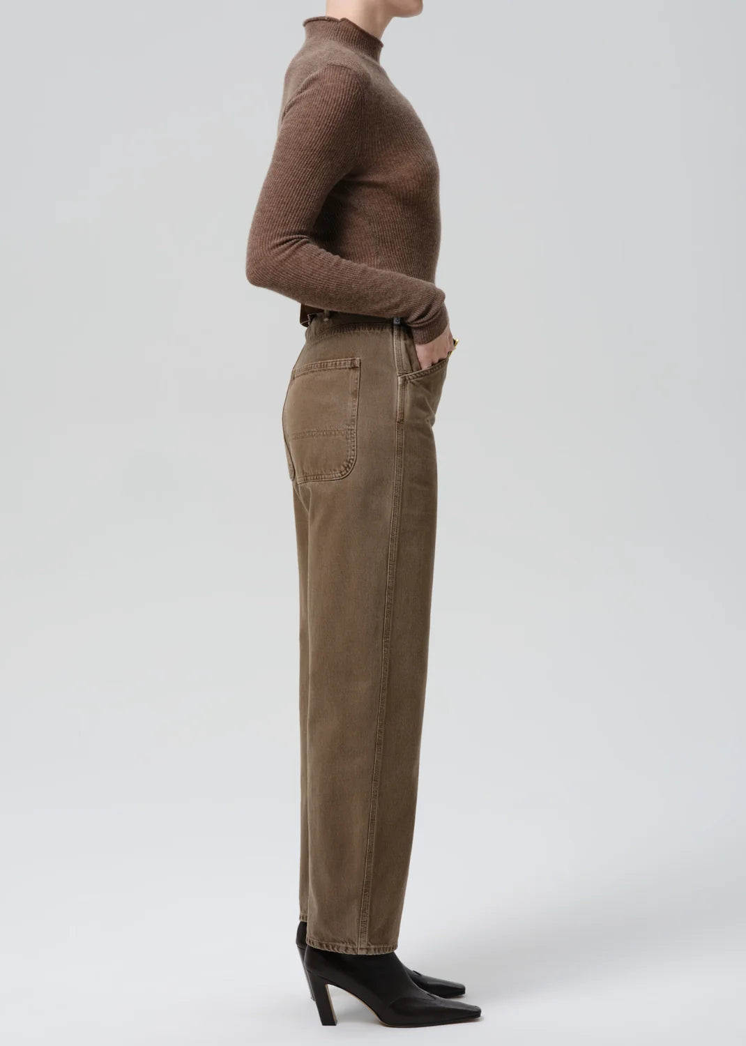 Miro Full Length Deck Pant by Citizens Of Humanity/AGOLDE in profile, paired with a brown sweater and black boots.
