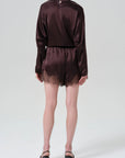 Lace trimmed tap shorts and dark satin top by Citizens Of Humanity AGOLDE, model back facing in black heels.