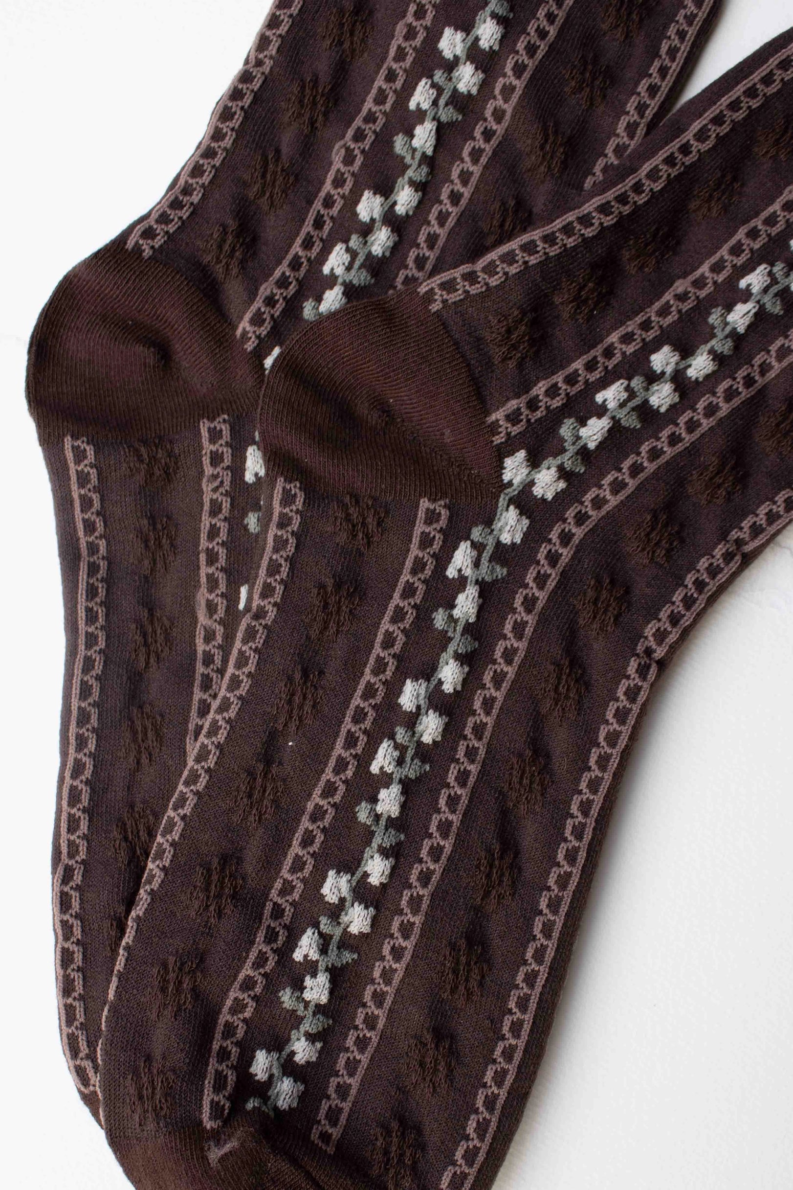 The Faire Vintage Stripe Floral Socks in dark brown feature a textured pattern with vertical light gray diamond shapes and are shown laid flat and overlapping on a white background.