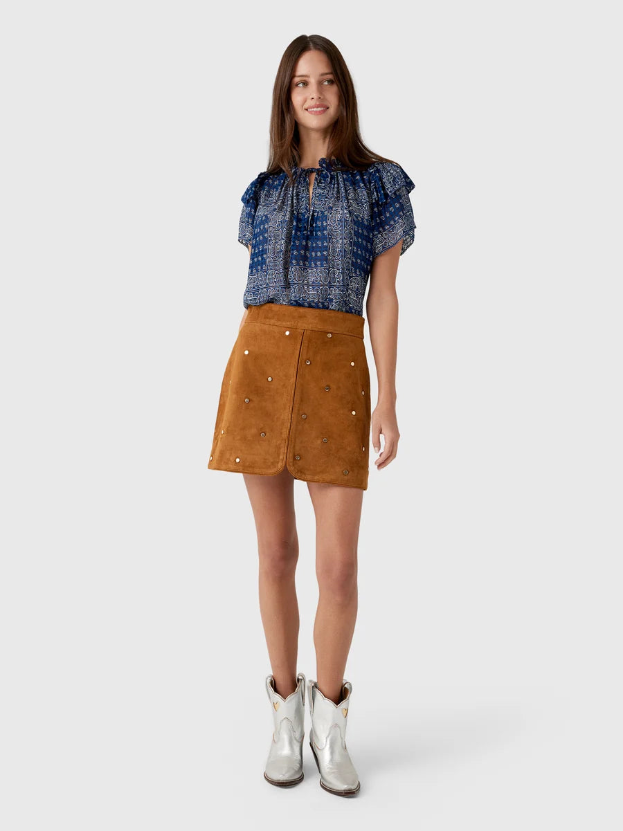 Hunter Bell NYC Dottie Skirt styled with blue patterned top and white cowboy boots, casual modern look.