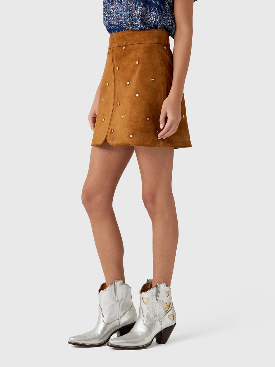 Hunter Bell NYC Dottie Skirt paired with a blue patterned top and silver studded cowboy boots.