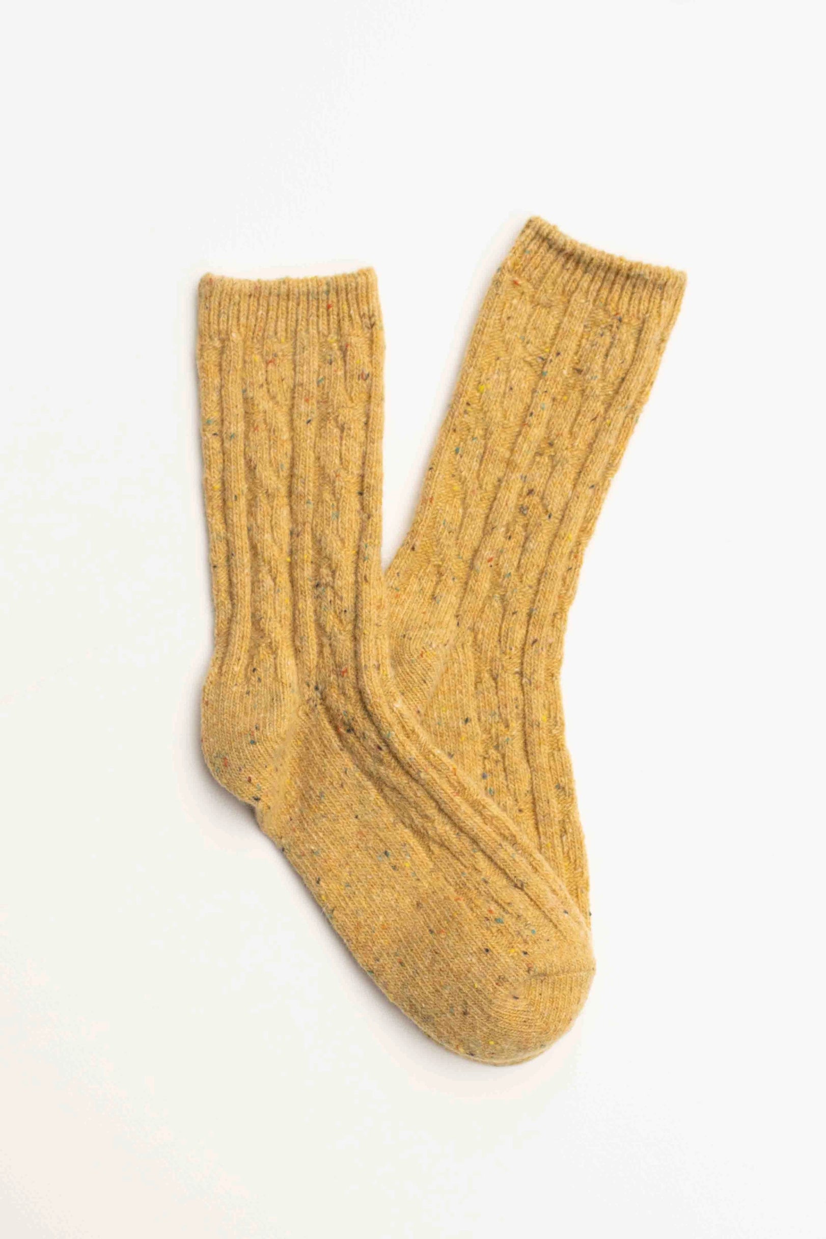 Faire Wool Speckled Knit Socks in mustard yellow feature a ribbed texture and colorful flecks, shown laid flat on a white background.