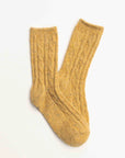 Faire Wool Speckled Knit Socks in mustard yellow feature a ribbed texture and colorful flecks, shown laid flat on a white background.