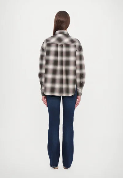 A person with long straight hair, seen from behind, wears the CLOSED Cropped Front OS Shirt and dark blue flared jeans, standing against a plain white background.