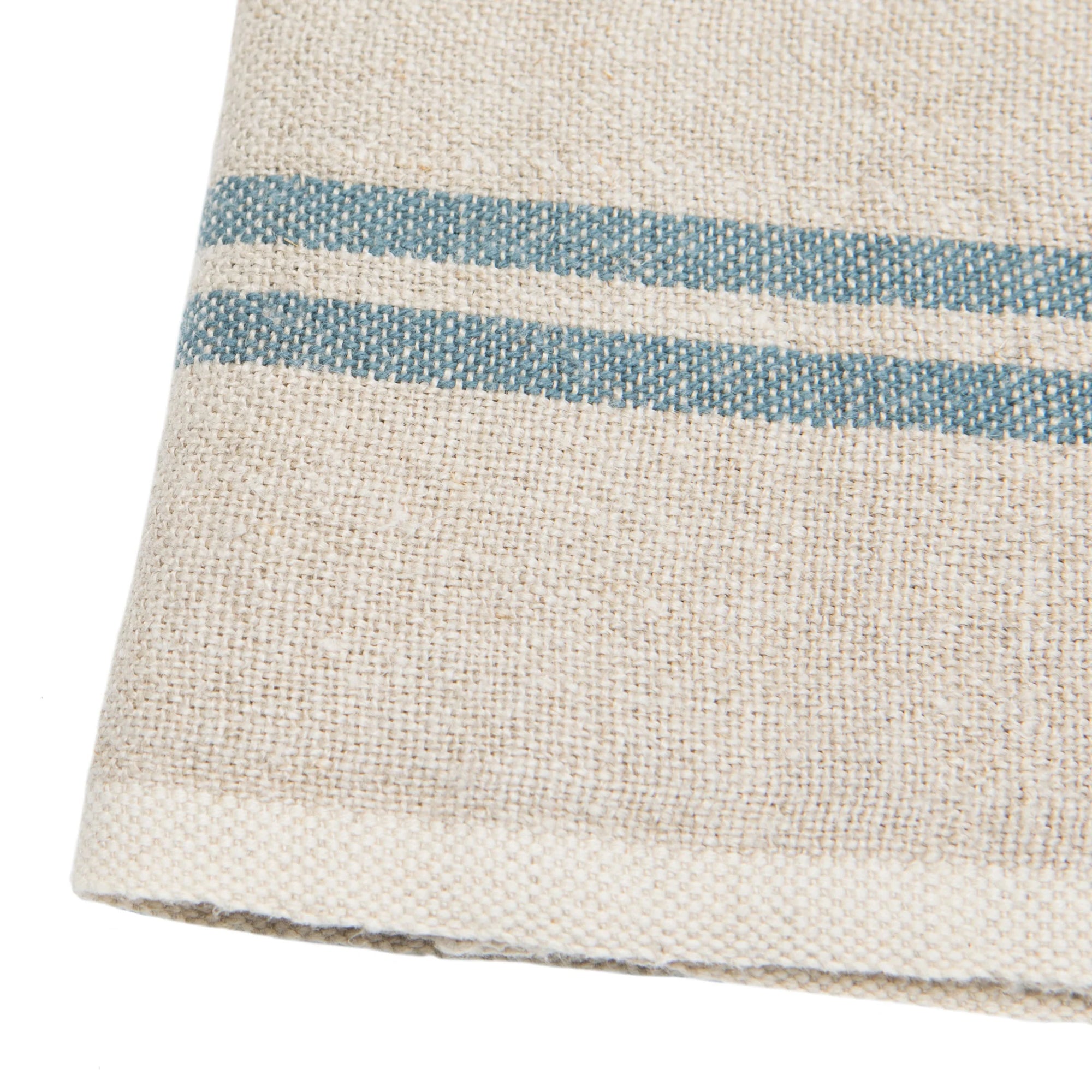 A close-up of Caravan’s Vintage Linen Towels Set-2 in beige, featuring two parallel blue stripes near the edge, highlights the rustic charm and texture of these classic table linens.