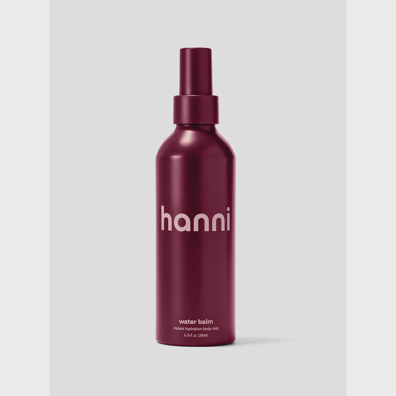 The Hanni Water Balm by Faire, a burgundy spray bottle with sleek, minimalist cylindrical packaging and matching cap, delivers refreshing moisture for instant hydration against a simple light gray background.