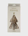 A package of Faire's Tinsel is displayed, featuring a tree-shaped cutout that reveals the shiny holiday decor inside. The word "TINSEL" glimmers on the front, with a small star and "GOLD" elegantly printed below.