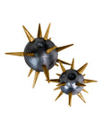 The Import Collection's Punk Candleholder features two metallic spherical pieces with gold spikes, offering an edgy accent for industrial home decor. Set against a white background.