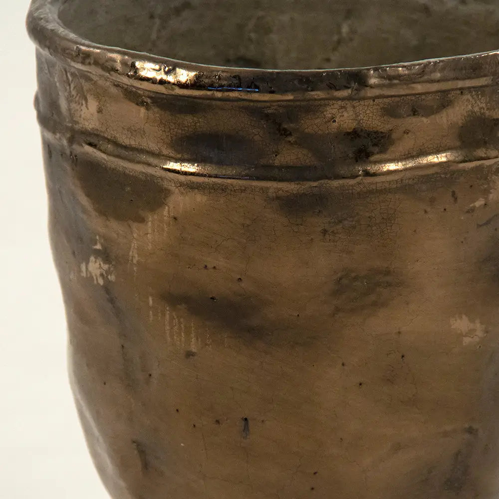 Close-up of the Zentique Distressed Bronze Vase reveals a hand-crafted, uneven metallic finish, subtle imperfections, and an irregular rim—details that highlight its unique opening diameter and overall dimensions.