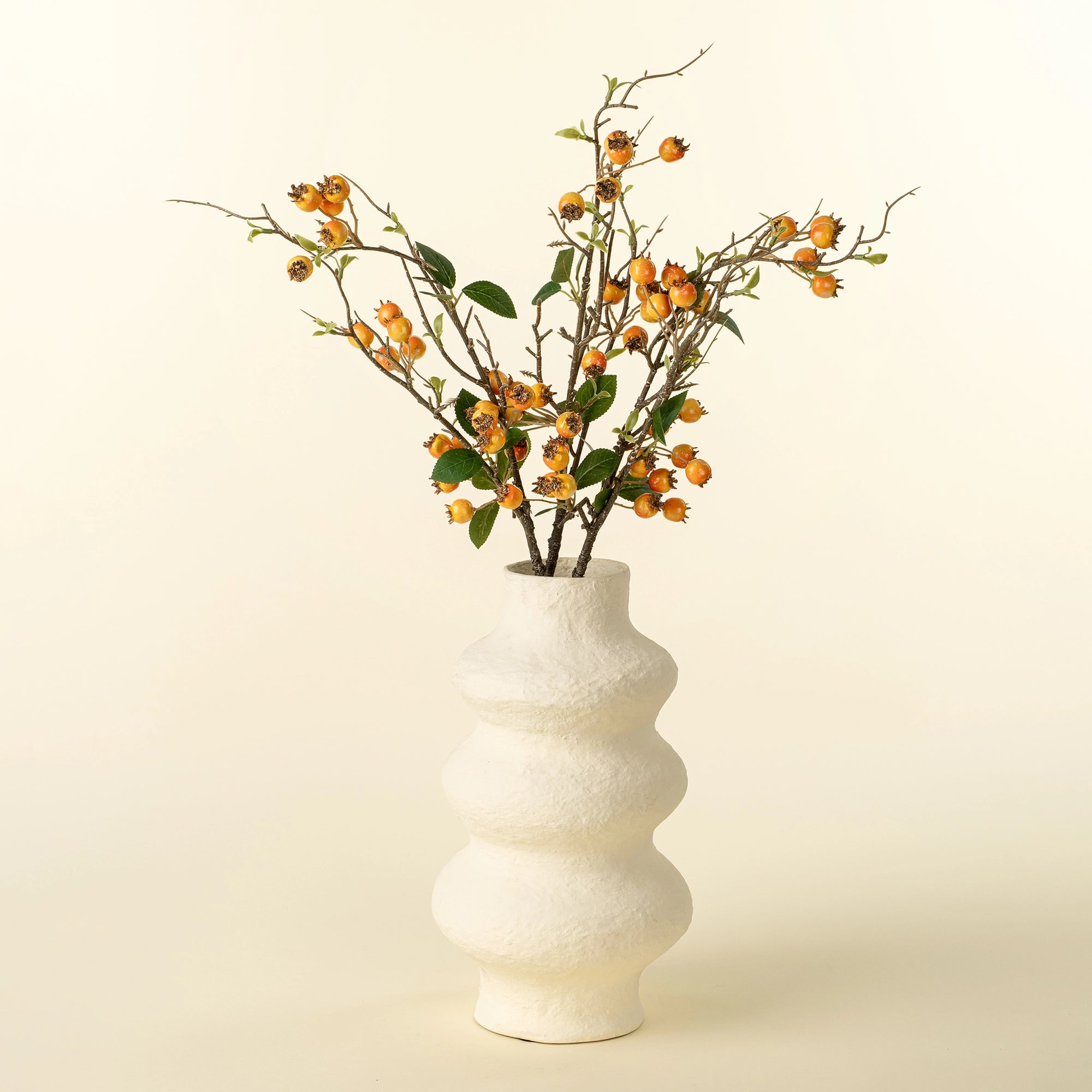 Orange rosehip branch with faux green leaves in white vase, accent decor by Faire for Bungalow Furniture.