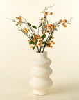 Orange rosehip branch with faux green leaves in white vase, accent decor by Faire for Bungalow Furniture.