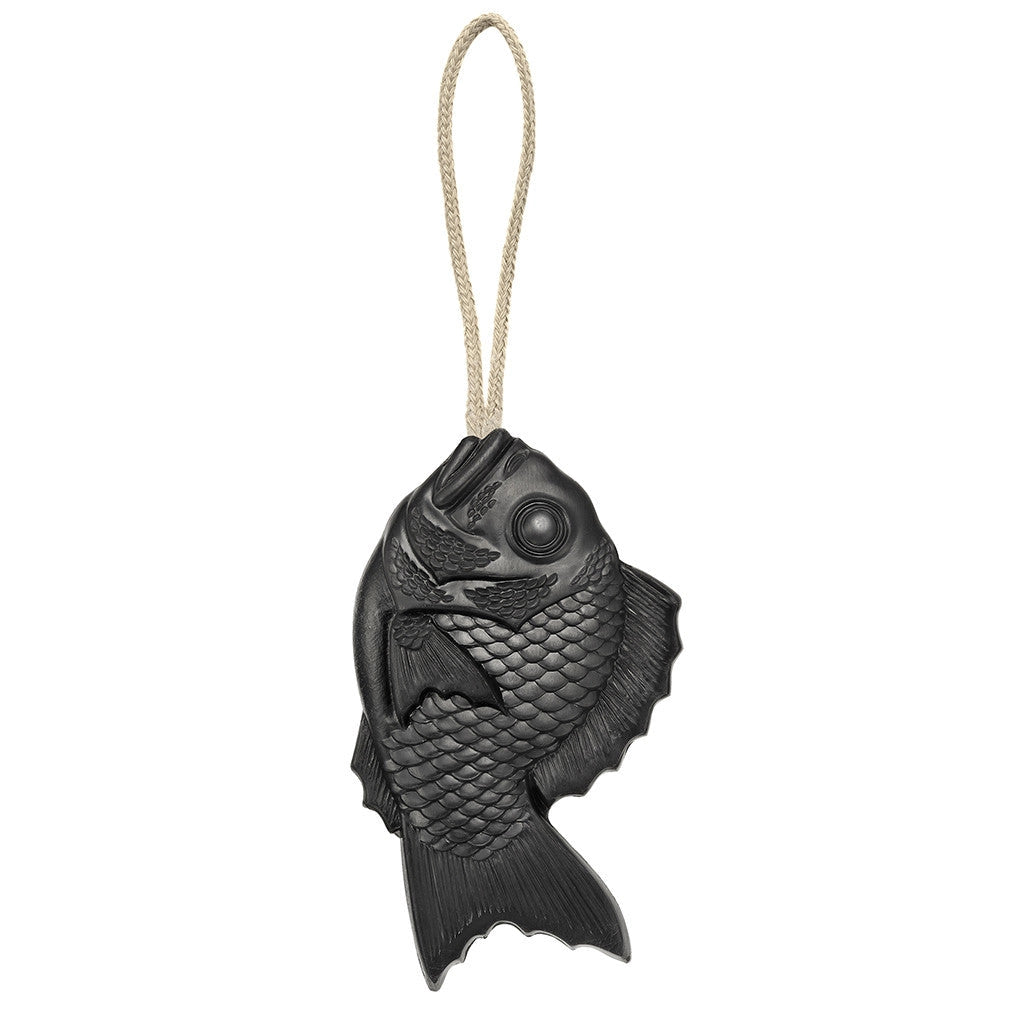 A black fish-shaped cast iron bell with detailed scales and fins and a beige rope loop evokes the look of traditional Japanese Tamanohada Soap by Faire.