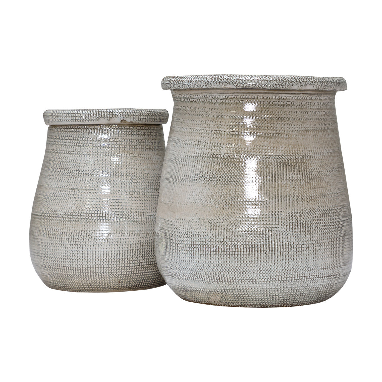 The Import Collection’s Elpine Short Vase is a textured, light-colored ceramic vase with a subtle woven pattern and wide opening, ideal as an accent on round tables. Shown alongside a matching larger vase on a white background.