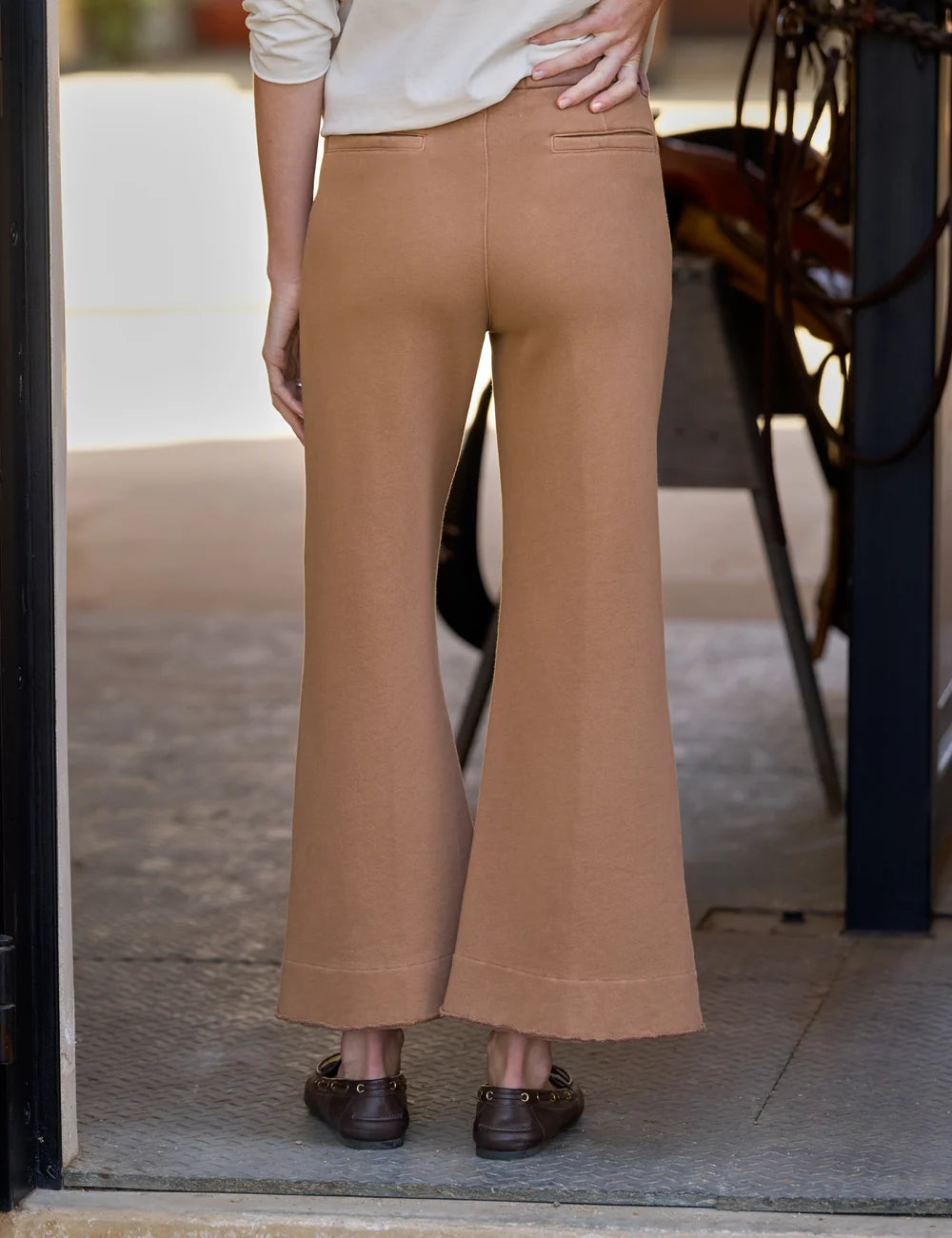 Wide leg Frank &amp; Eileen Riley trousers in brown, seen from the back as worn in a doorway, casual lifestyle setting.