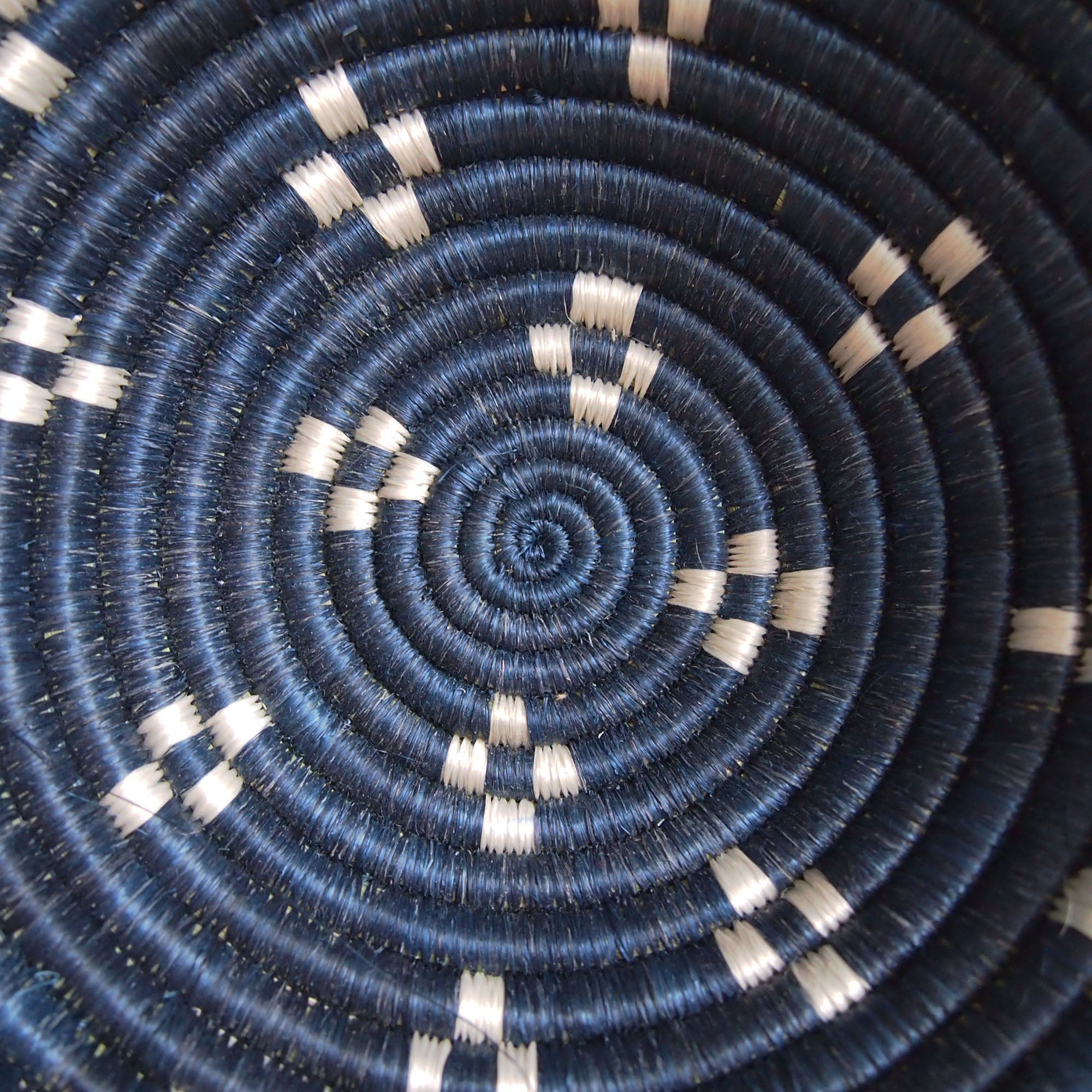 Close-up of the Kabaya Small bowl lid by Amsha - Faire, showing dark blue and white concentric circles in a spiral pattern with evenly spaced white accents radiating from the center.