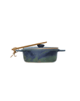 Creative Co-op's Stoneware Brie Baker with Bamboo Spreader features a blue and green glaze, lid, and string-tied bamboo-style spoon resting on top. It includes small handles on each side for easy handling.