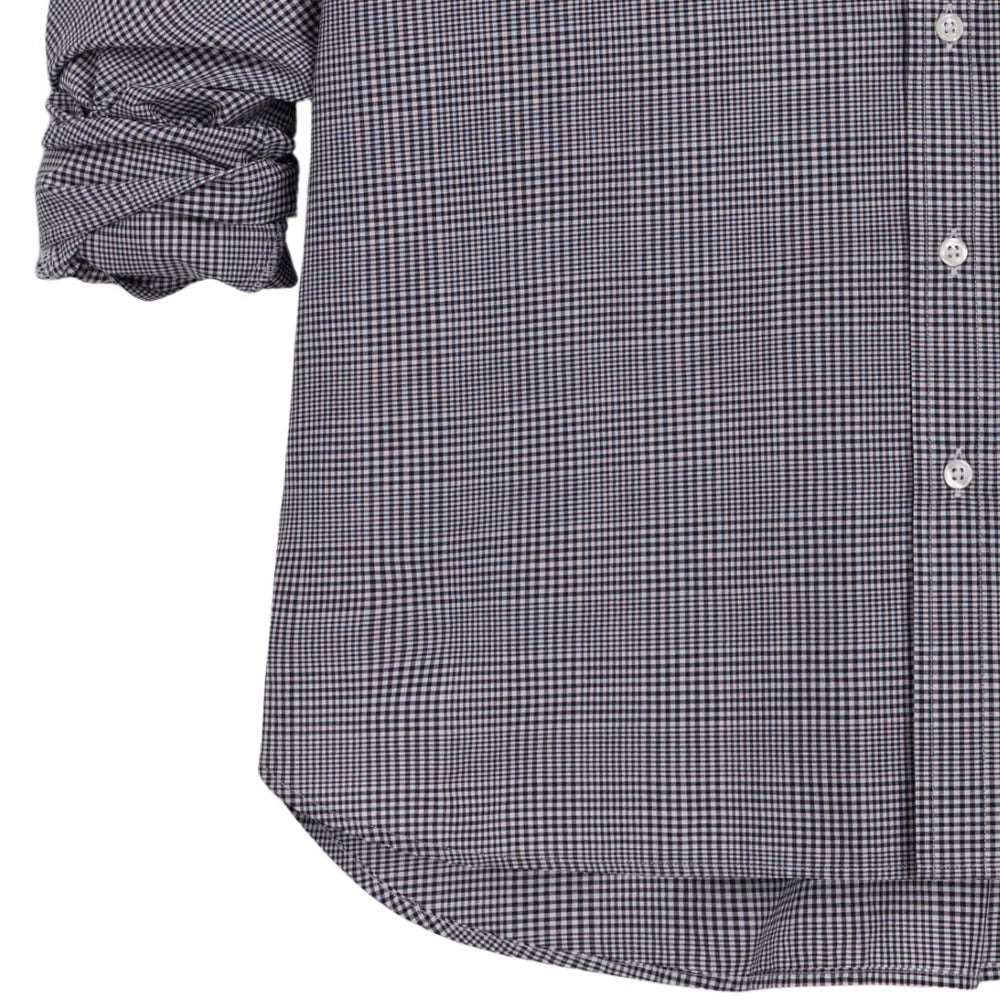 A close-up of a person wearing the Oona Continuous Button-Up Shirt by Frank & Eileen, a relaxed fit, black and white checkered long-sleeve 100% cotton shirt with rolled-up sleeves. Only the torso and arms are visible.