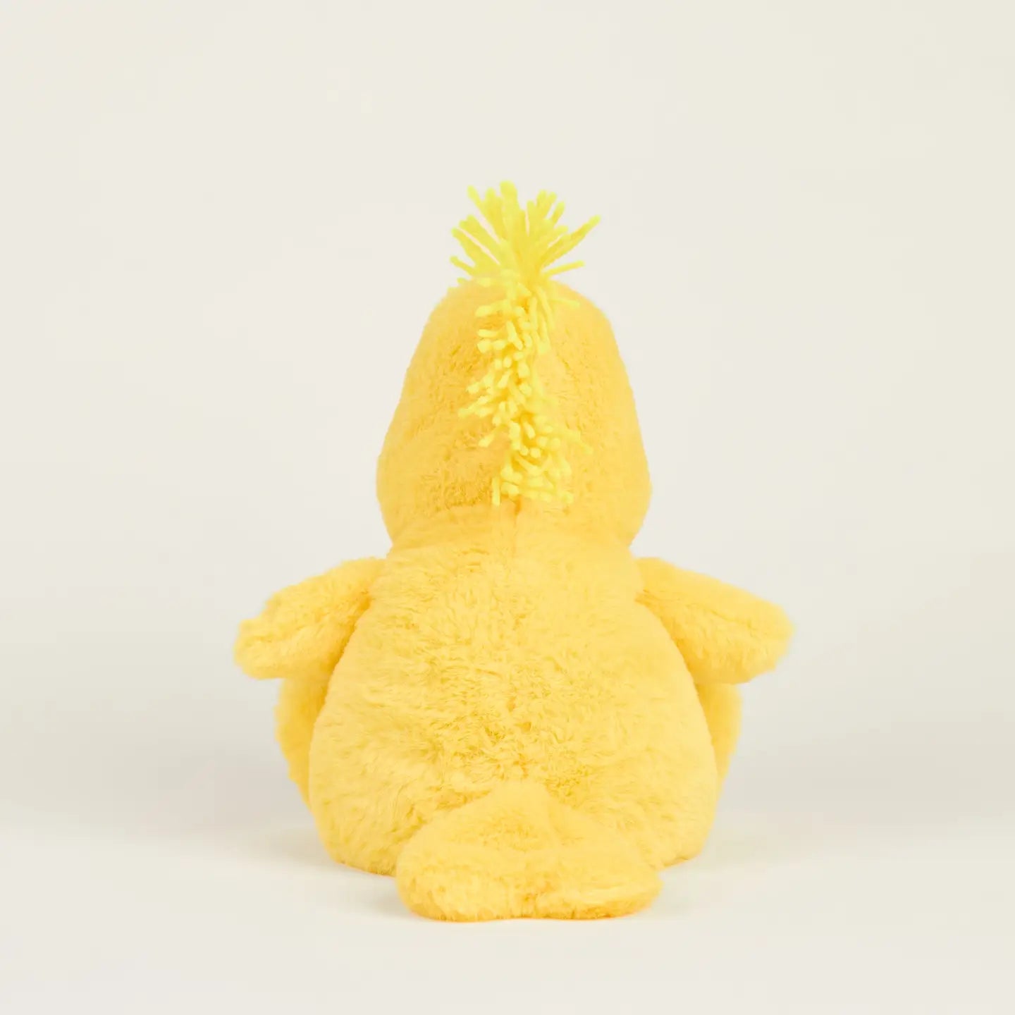 The Woodstock Warmies by Warmies/Intelex is a microwavable plush yellow bird shown from the back on a plain white background, featuring two wings, a tail, and a spiky yellow tuft for sensory comfort.
