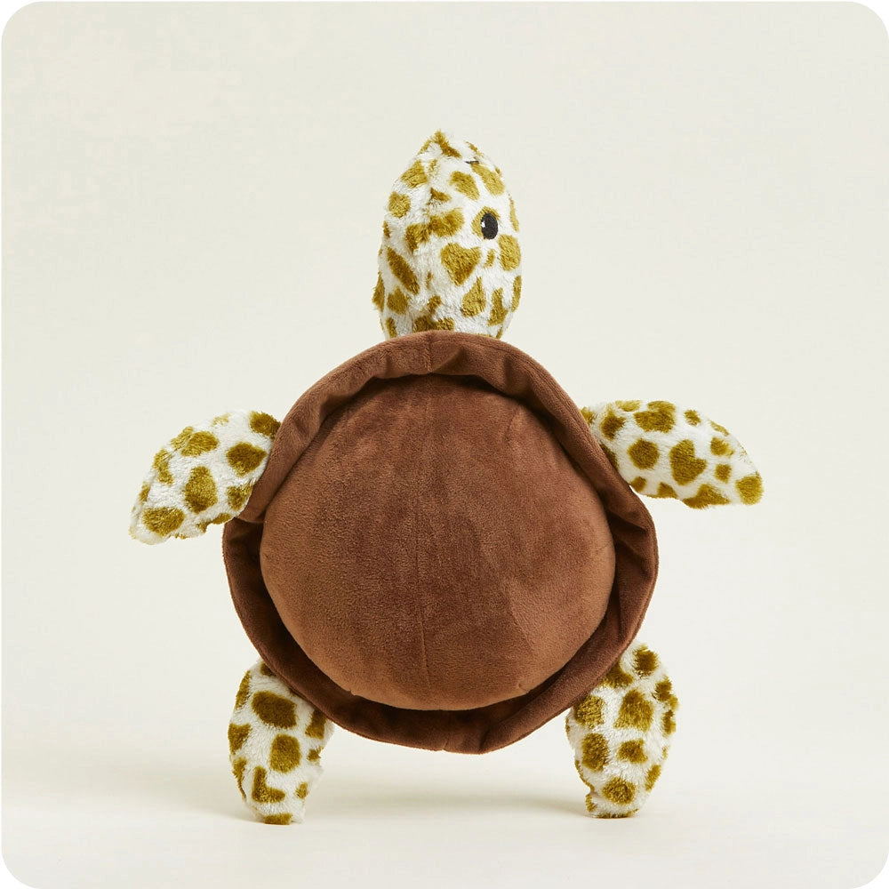 The Faire Turtle Warmies is a microwavable plush with a soft brown shell and yellow-and-white spotted details, providing soothing sensory comfort when placed upright against a light background.