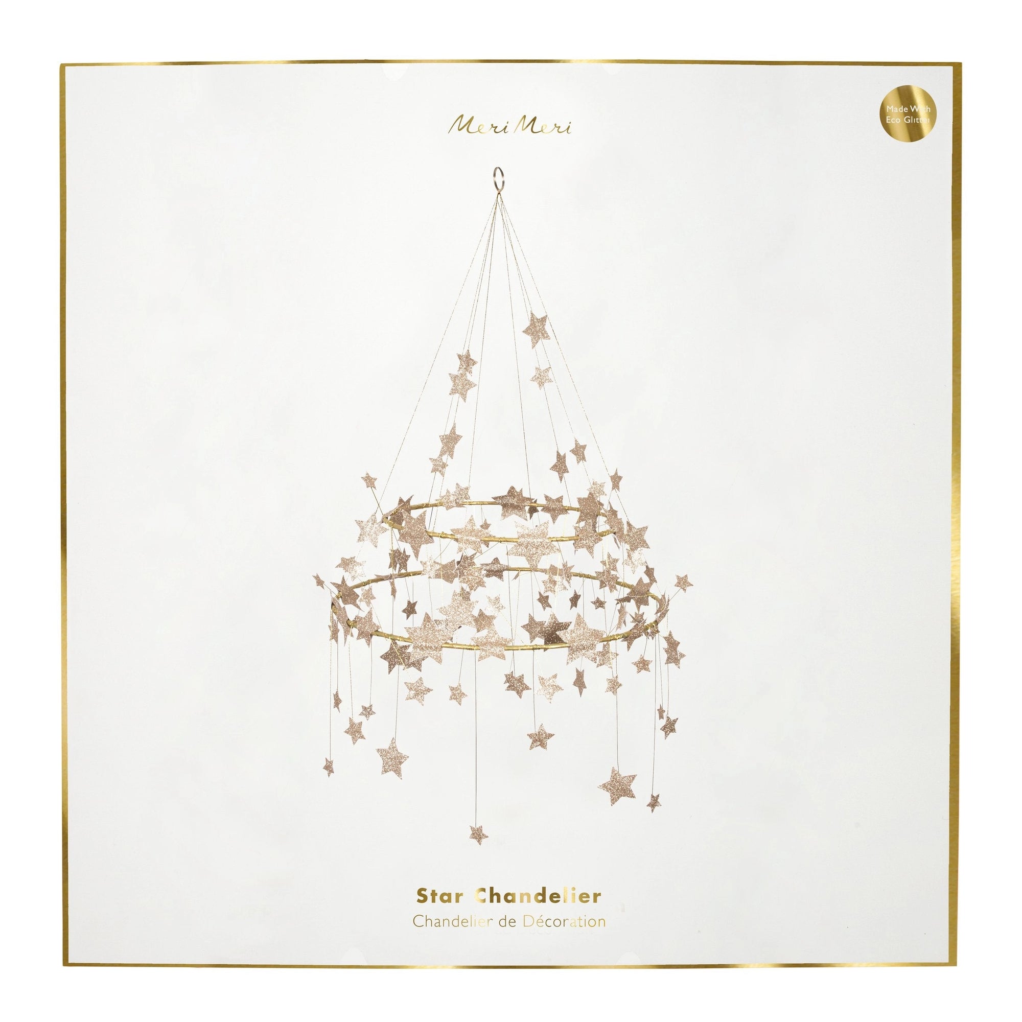 The Gold Sparkle Star Chandelier by Faire comes in a decorative box with a pajaki-inspired illustration of a hanging star chandelier, gold glitter stars, and “Gold Sparkle Star Chandelier” written in gold text, framed with a thin gold border.
